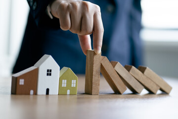 Businesswomen's hand stopping falling collapse wooden block dominoes effect continuous toppled home wood small, economic crisis, business bankruptcy, preventing risk, financial, insurance concept.
