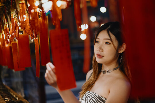 Young Woman Observing Red Lanterns in Temple