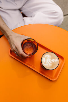 Hands of an unrecognizable woman holding a coffee cup with latte art