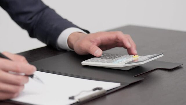 電卓で見積もりを計算するビジネスマンの手元