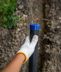 Obraz premium Pipe contractor install new HDPE pipes under the ground in village,