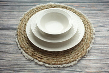 An Elegant White Dinnerware Set Displayed Beautifully on a Rustic Table Mat for Dining