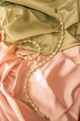 Jade and pearl handmade necklace and bracelet on green and beige satin background