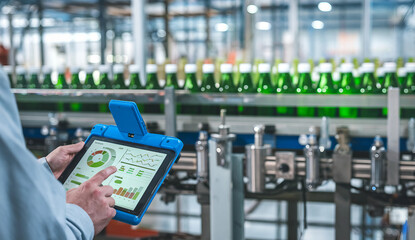 Factory worker using digital tablet for production line monitoring 