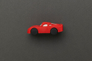 Minimalist Red Toy Car on Dark Green Background in Artistic Composition