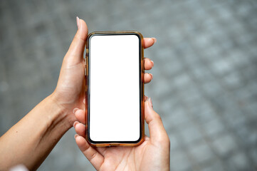 A close-up of a woman's hand holding a smartphone, set against a blurred background of a street.