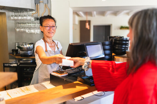 Waiter Handing Ticket to Customer in Korean Restaurant