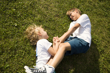 Children playing happily on the grass during a sunny day at a park