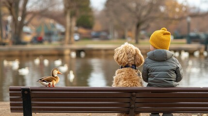 A child and a dog sit on a bench by a pond, observing a duck in a tranquil park setting.