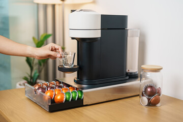 hand making Espresso Coffee by Coffee Maker Machine with Capsule of roasted coffee bean on wood...