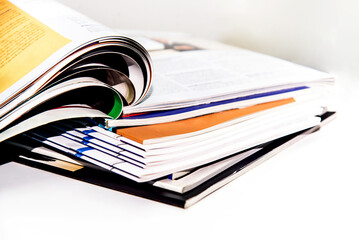 Stack of magazines on white background. Shallow depth of field.