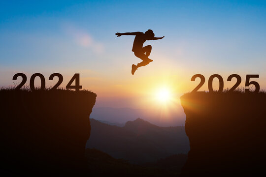 Happy new year 2025 concept. Silhouette of man jump on the cliff between 2024 to 2025 years over sunset or sunrise background.