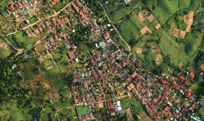 Aerial view of a village nestled in a lush green landscape.