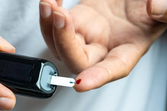 hand of people check diabetes and high blood glucose monitor with digital pressure gauge. Healthcare and Medical concept	