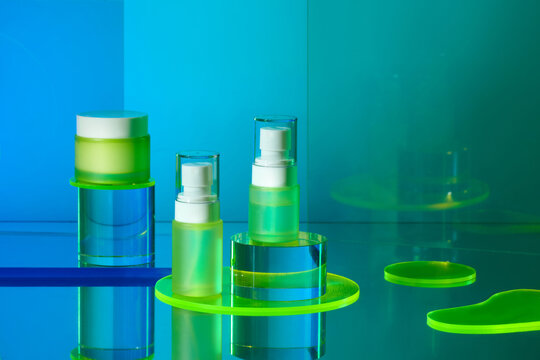 Modern Skincare Products On Glass Surface With Blue Green Background