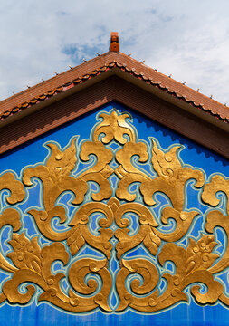 Ornate Golden Designs on Blue Temple Wall