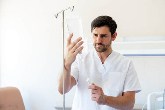 Nurse adjusting IV drip in hospital room