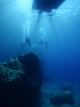 scuba divers coming up to surface end of dive underwater