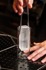 Bartender Preparing a Drink with Ice at the Bar