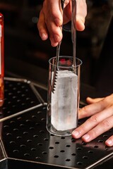 Bartender Preparing a Drink with Ice at the Bar