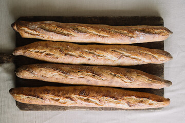Top view of four baguettes lined on wooden board image
