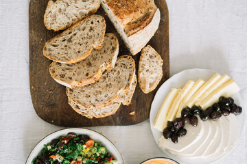 Assorted dips and bread on a table with white cloth