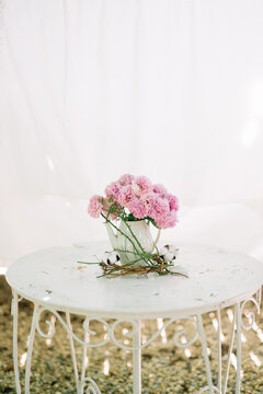 Pink flowers arranged on vintage white round table