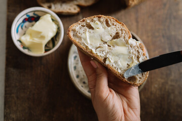 Generous spread of butter on a rustic bread slice.