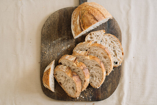 Slices of sourdough bread on a rustic wooden board.
