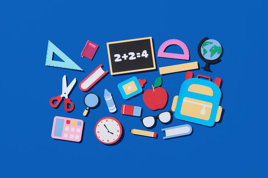 Arrangement of colorful school supplies on a blue background