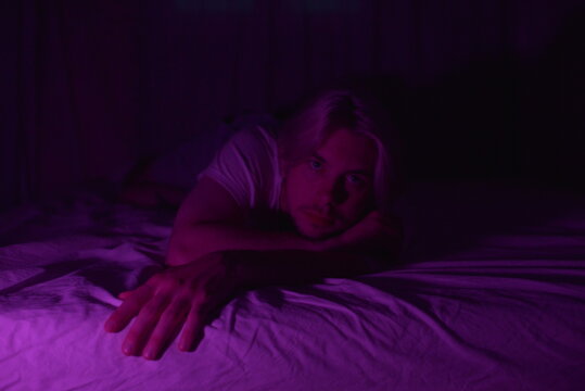 A young man portrait with magenta light