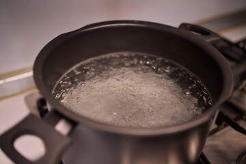 Boiling water in a pot placed atop the stove can create bubbles and steam during cooking