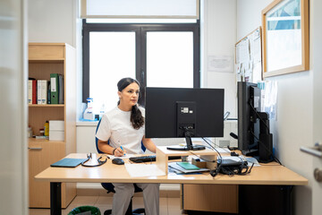 Medical professional working on computer in office