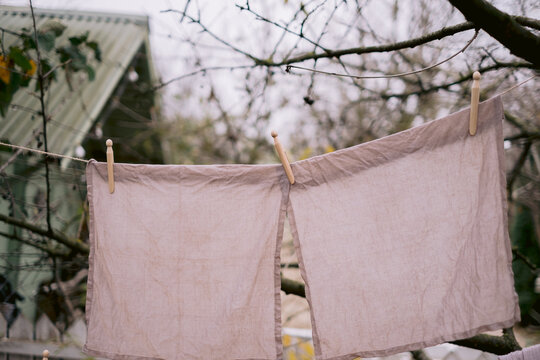 Pastel-colored fabrics drying neatly with wooden pegs.