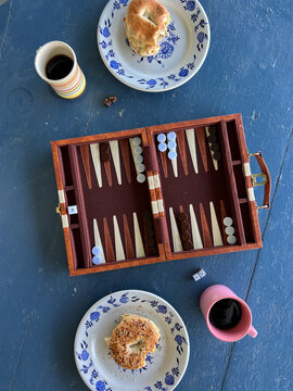 Backgammon Game Board and Breakfast Sandwiches on Outdoor Table