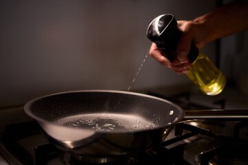Carefully pouring oil into a pan to prepare for cooking various delicious meals and dishes