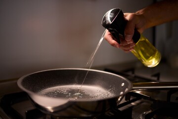 Carefully pouring oil into a pan to prepare for cooking various delicious meals and dishes