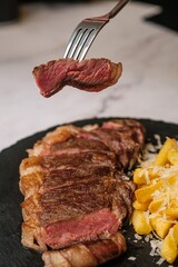 Delicious Steak Bite on Fork with Garnish in Background