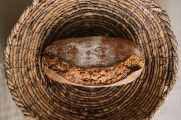 Loaf of freshly baked bread in a woven basket top view