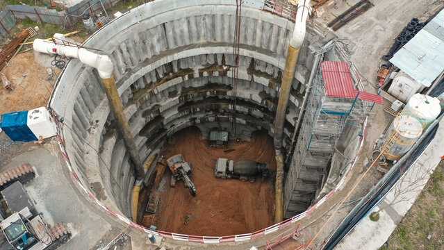 excavator and concrete mixer in metro tunnel shaft construction