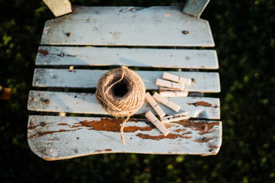Roll of twine and clothespins on rustic wooden chair