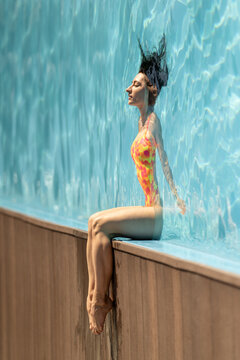 Woman is posing in sunny swimming pool