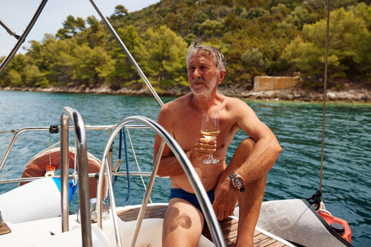 Sailing man enjoying wine on the deck