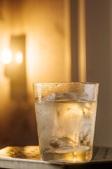 Refreshing Cocktail with Large Ice on a Table and Lamp