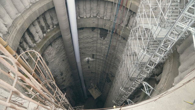 crane bucket being lowered at mine tunnel shaft construction