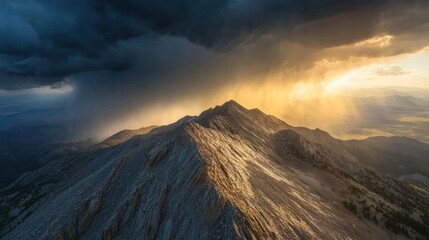 Fototapeta premium Storm clouds swirling over a mountain ridge, with sunlight breaking through the cracks.