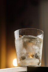 Refreshing Cocktail with Large Ice on a Table and Lamp