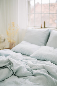 Sunlit cozy bed with soft sheets and pillows serene vibe