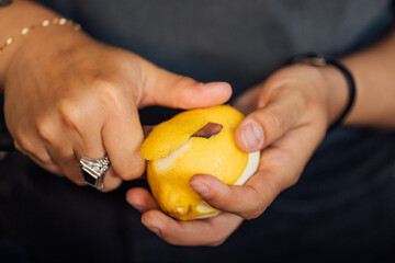 Bartender peeling lemon for cocktail