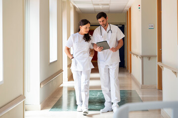 Healthcare professionals discussing patient care in hospital corridor